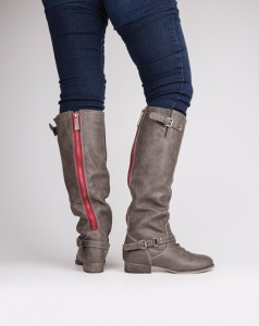 Cara’s Boutique These boots feature a soft and smooth distressed leatherette material. These boots pop with  a zipper on the back with a red backing that is sure to stand out.